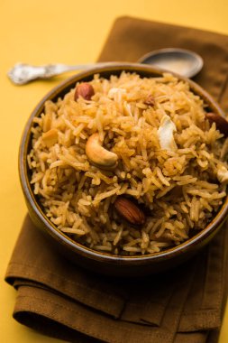 Hintçe Geleneksel Jaggery Pirinç veya Gur wale chawal, kaşıkla bir kase servis. seçici odaklama