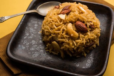 Hintçe Geleneksel Jaggery Pirinç veya Gur wale chawal, kaşıkla bir kase servis. seçici odaklama