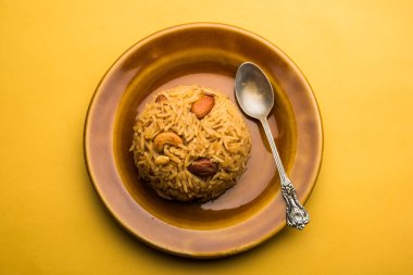 Hintçe Geleneksel Jaggery Pirinç veya Gur wale chawal, kaşıkla bir kase servis. seçici odaklama