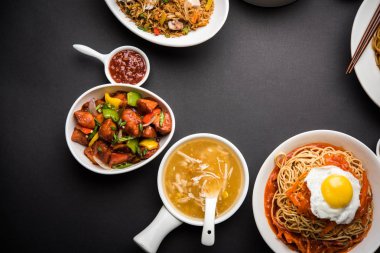 Çeşitli Indo çin gıda grup olmayan vejetaryen veya tavuk Schezwan / Szechuan hakka erişte, kızarmış pirinç, mançurya, yumurta amerikan pirzola suey, kaşık ve doğrama çubukları ile çorba, seçici odak içerir