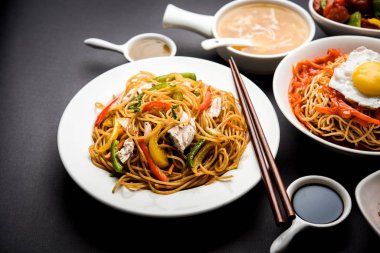 Çeşitli Indo çin gıda grup olmayan vejetaryen veya tavuk Schezwan / Szechuan hakka erişte, kızarmış pirinç, mançurya, yumurta amerikan pirzola suey, kaşık ve doğrama çubukları ile çorba, seçici odak içerir