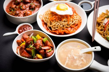 Çeşitli Indo çin gıda grup olmayan vejetaryen veya tavuk Schezwan / Szechuan hakka erişte, kızarmış pirinç, mançurya, yumurta amerikan pirzola suey, kaşık ve doğrama çubukları ile çorba, seçici odak içerir