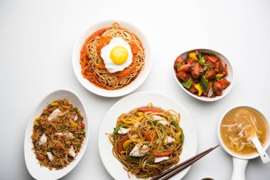 Çeşitli Indo çin gıda grup olmayan vejetaryen veya tavuk Schezwan / Szechuan hakka erişte, kızarmış pirinç, mançurya, yumurta amerikan pirzola suey, kaşık ve doğrama çubukları ile çorba, seçici odak içerir