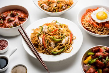 Çeşitli Indo çin gıda grup olmayan vejetaryen veya tavuk Schezwan / Szechuan hakka erişte, kızarmış pirinç, mançurya, yumurta amerikan pirzola suey, kaşık ve doğrama çubukları ile çorba, seçici odak içerir