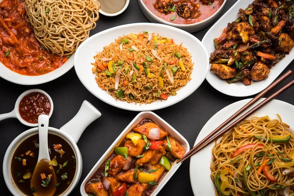 Assorted Indo chinese food in group includes Schezwan/Szechuan hakka noodles, veg fried rice, veg manchurian, american chop suey, chilli paneer, crispy vegetable and vegetable soup