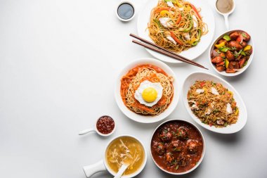 Çeşitli Indo çin gıda grup olmayan vejetaryen veya tavuk Schezwan / Szechuan hakka erişte, kızarmış pirinç, mançurya, yumurta amerikan pirzola suey, kaşık ve doğrama çubukları ile çorba, seçici odak içerir