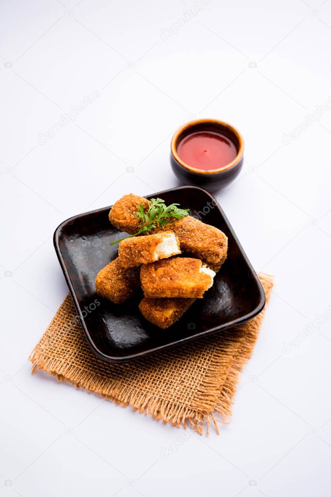 Kurkuri paneer fingers or pakora/pakoda snacks also known as Crispy Cottage Cheese Bars, served with tomato ketchup as a starter. selective focus