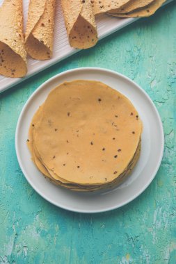 Kavrulmuş koni, rulo ve düz varyasyon ile çiğ kurutulmuş formda Gujarati Papad veya Papadum