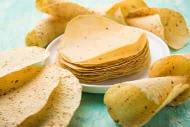 Kavrulmuş koni, rulo ve düz varyasyon ile çiğ kurutulmuş formda Gujarati Papad veya Papadum