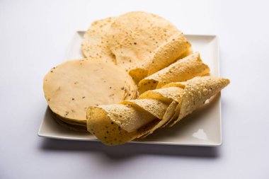 Kavrulmuş koni, rulo ve düz varyasyon ile çiğ kurutulmuş formda Gujarati Papad veya Papadum