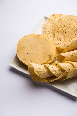 Kavrulmuş koni, rulo ve düz varyasyon ile çiğ kurutulmuş formda Gujarati Papad veya Papadum