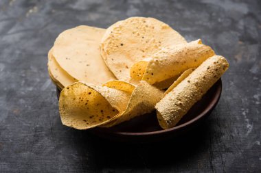Kavrulmuş koni, rulo ve düz varyasyon ile çiğ kurutulmuş formda Gujarati Papad veya Papadum