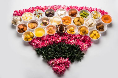 Flower Rangoli with sweets/mithai and diya in bowls for Diwali or any other festivals in India, selective focus clipart