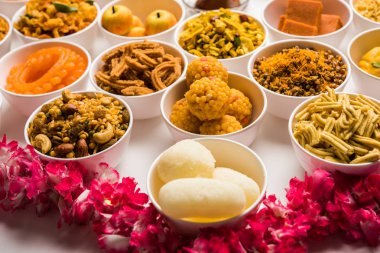 Beyaz arka plan üzerinde diya ile Diwali için kase tatlılar ve Farsan / aperatifler Rangoli