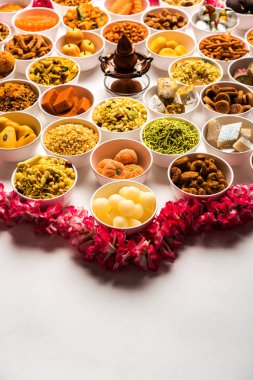 Beyaz arka plan üzerinde diya ile Diwali için kase tatlılar ve Farsan / aperatifler Rangoli