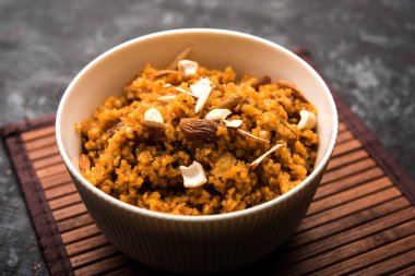 Buğday Laapsi / Lapsi / Shira / Halwa fındık, kuru üzüm ve kurutulmuş meyve ile birlikte kırık buğday veya Daliya adet ve ghee yapılmış bir Hint tatlı yemektir. Sağlıklı bir yiyecek. bir kase, seçici odak hizmet