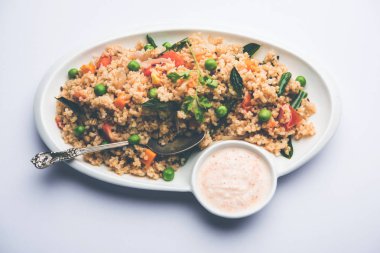 Kırık buğday veya Daliya Upma, bir kase de servis edilir. seçici odaklama