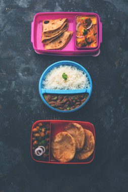 Tiffin 'deki Kuzey Hint Yemekleri Grubu, Beslenme Kutusu Rajma veya Razma Chawal, Paneer Butter Masala Roti veya Paratha ve choley puri / Poori / Bhature, seçici odaklanma