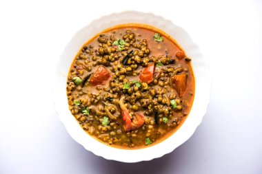 Tadka 'nın tüm yeşil Moong Dal kızartması ve tüm Mung fasulyesi bir kasede servis edilir. seçici odak