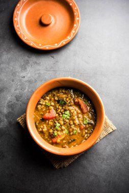 Tadka 'nın tüm yeşil Moong Dal kızartması ve tüm Mung fasulyesi bir kasede servis edilir. seçici odak
