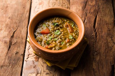 Tadka 'nın tüm yeşil Moong Dal kızartması ve tüm Mung fasulyesi bir kasede servis edilir. seçici odak