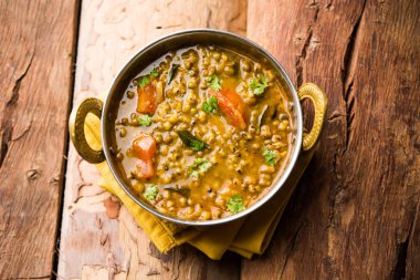 Tadka 'nın tüm yeşil Moong Dal kızartması ve tüm Mung fasulyesi bir kasede servis edilir. seçici odak