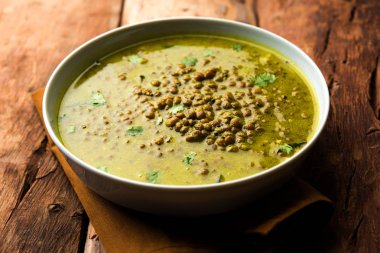 Siyah Masoor Dal kızartması ya da Dhaba Stili Sabut Kırmızı Mercimek dhal tadka yeşil köri ile servis edilir. seçici odak