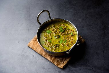 Siyah Masoor Dal kızartması ya da Dhaba Stili Sabut Kırmızı Mercimek dhal tadka yeşil köri ile servis edilir. seçici odak