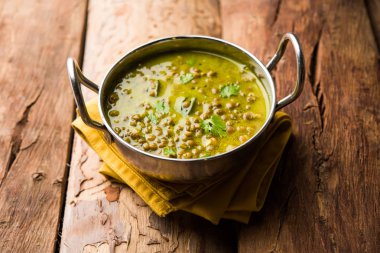 Siyah Masoor Dal kızartması ya da Dhaba Stili Sabut Kırmızı Mercimek dhal tadka yeşil köri ile servis edilir. seçici odak