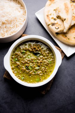 Siyah Masoor Dal kızartması ya da Dhaba Stili Sabut Kırmızı Mercimek dhal tadka yeşil köri ile servis edilir. seçici odak