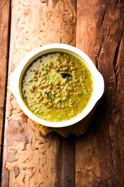 Siyah Masoor Dal kızartması ya da Dhaba Stili Sabut Kırmızı Mercimek dhal tadka yeşil köri ile servis edilir. seçici odak