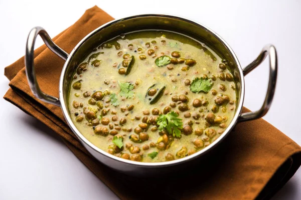 Siyah Masoor Dal kızartması ya da Dhaba Stili Sabut Kırmızı Mercimek dhal tadka yeşil köri ile servis edilir. seçici odak