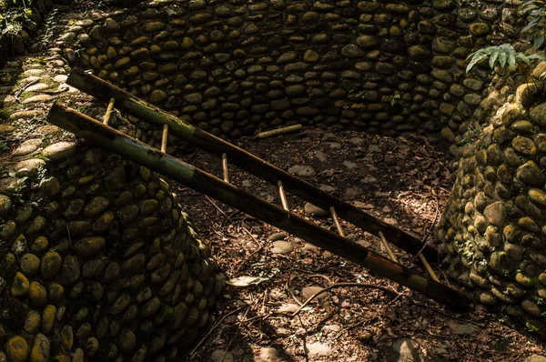 Escalera de madera en un pozo de piedras