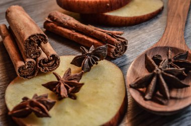 Yıldız anason, tarçın ve ahşap arka plan üzerinde elma