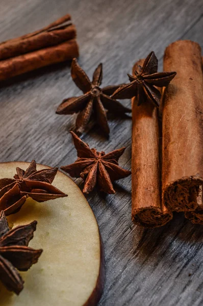 Yıldız anason, tarçın ve ahşap arka plan üzerinde elma