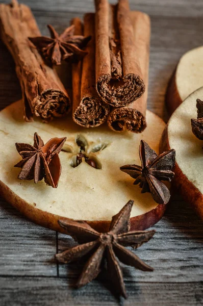 star anise, cinnamon and apple on wooden background