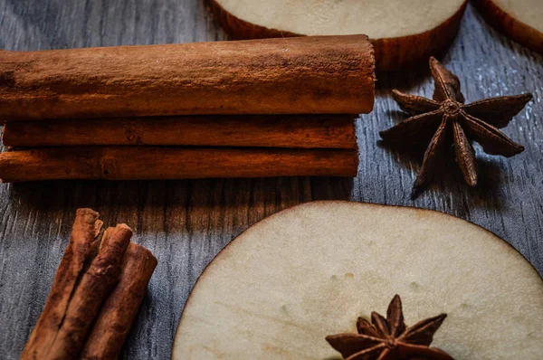 Yıldız anason, tarçın ve ahşap arka plan üzerinde elma