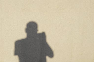Fotokopi alanı ve arkaplanı olan duvarın arka planında fotoğrafçının gölgesi
