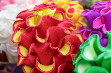 Hediye paketi için çok renkli parşömen kağıdından yapılmış çiçekler. Yakın plan, yüzeysel alan derinliği ile odaklan.