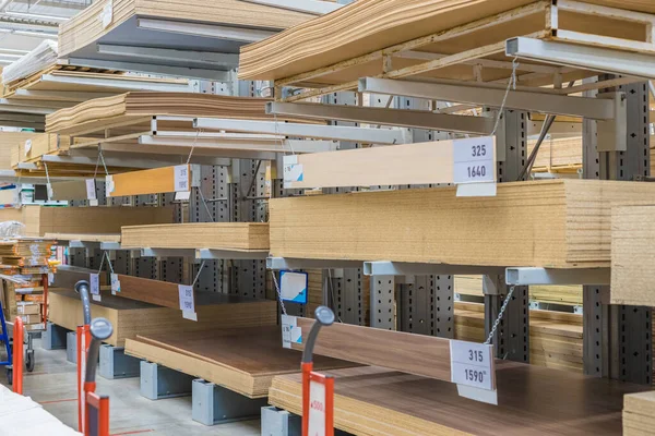 Modern warehouse with building wood materials on metal shelves. Selective focus. Renovation and construction concept.