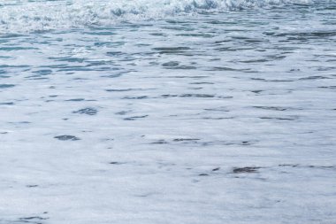 Sahilde köpüklü dalgaların dokusu, arka plan