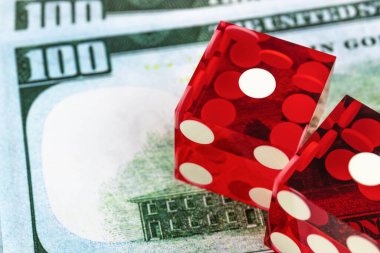 Bulanık banknotların üzerinde yan yana uzanan iki kırmızı zar, üst görünüm / kumar kavramı