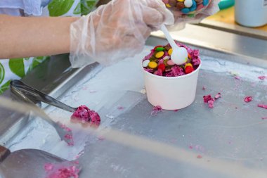 Elle kızartılmış dondurma pişirme işlemi. Sarılmış dondurma, karamel eklenmiş el yapımı tatlı. Sokak yemekleri konsepti.