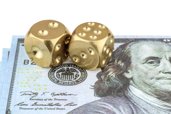 Two golden dice lie on a banknote with the face of Franklin, isolated on white. Successful business concept.