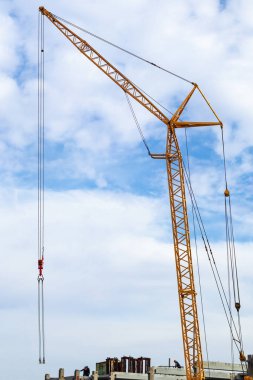 İnşaat alanı bir vinç ve inşaatçılar gökyüzüne karşı bulutlu beton yapılar.