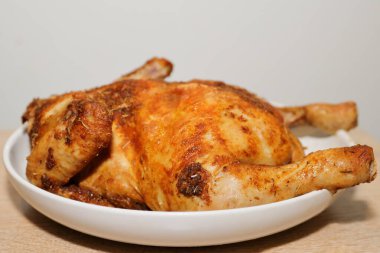 Kızarmış tavuk ve baharatlar yakın plan beyaz bir tabakta.