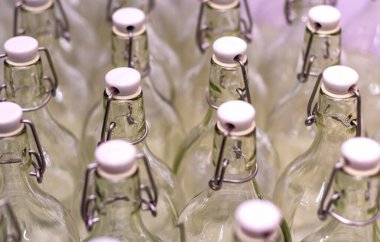 Kilitlenebilir plastik kapaklı yeni cam şişeler piyasada tek sıra halinde duruyor..