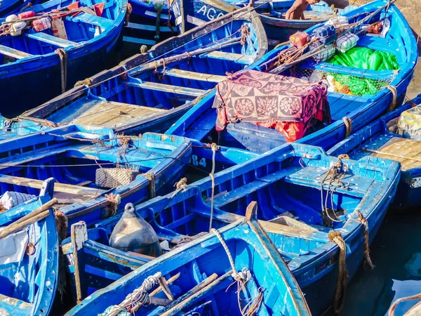 Vibrant blue wooden boats lined up in the harbor in Essaouira, Morocco