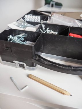 Grafit kalem yanındaki siyah bir plastik araç kutusu ile vida ve prizler duvarın üzerindeki işaretleri için kullanılan