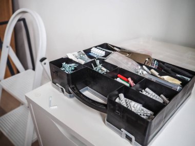 Siyah plastik araç kutusu birden fazla fiş ve üzerindeki beyaz bir duvar karşı ve bir merdiven yanında bir kabine ile